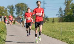 Läufer bei einem Wettkampf auf einer leicht hügeligen Laufstrecke