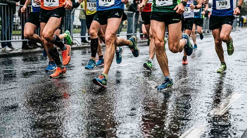 Läufer bei einem Laufwettkampf auf regennasser Strasse