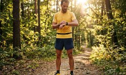 Läufer kontrolliert beim Joggen den Kalorienverbrauch auf seiner Sportuhr