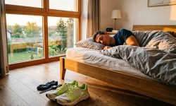 Lauschuhe vor dem Bett eines schlafenden Läufers