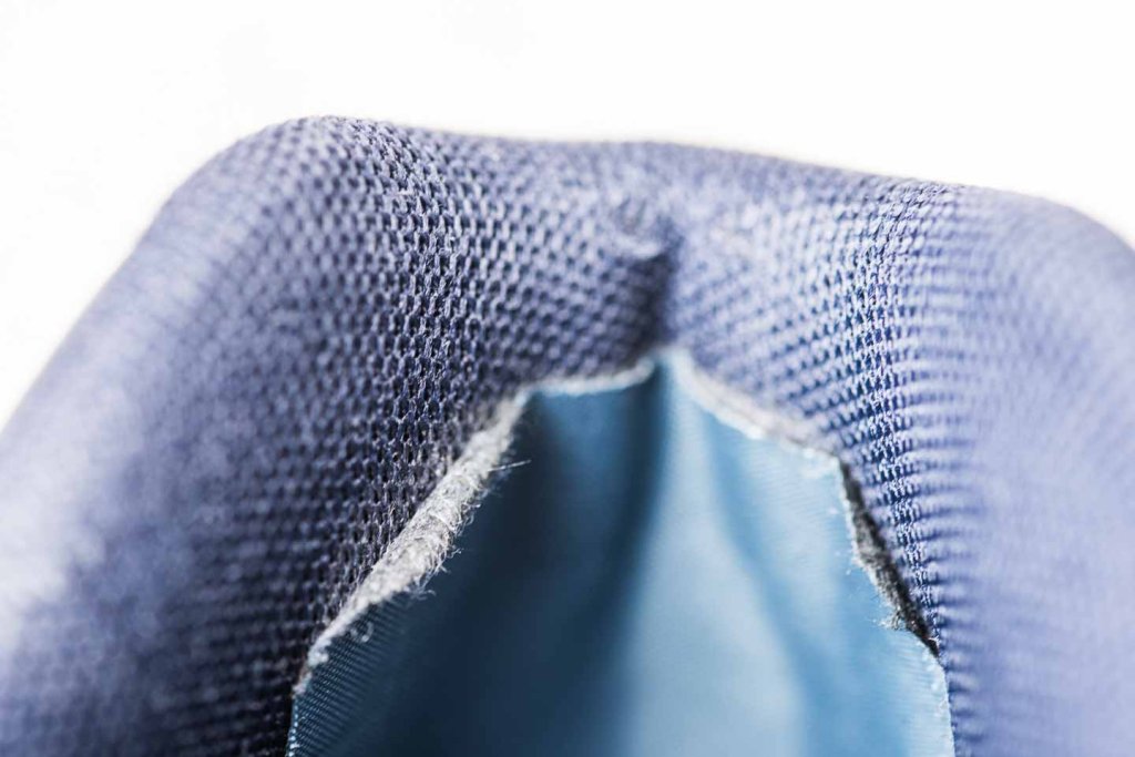 Fersenkappe reparieren – ausgefranste Kanten des Flickmaterials Ausgefranste Ränder eines Flickmaterials zur Reparatur einer Fersenkappe
