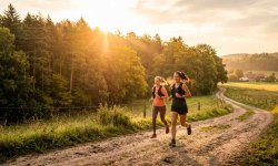 Zwei Läuferinnen absolvieren einen langen Dauerlauf auf einem Feldweg