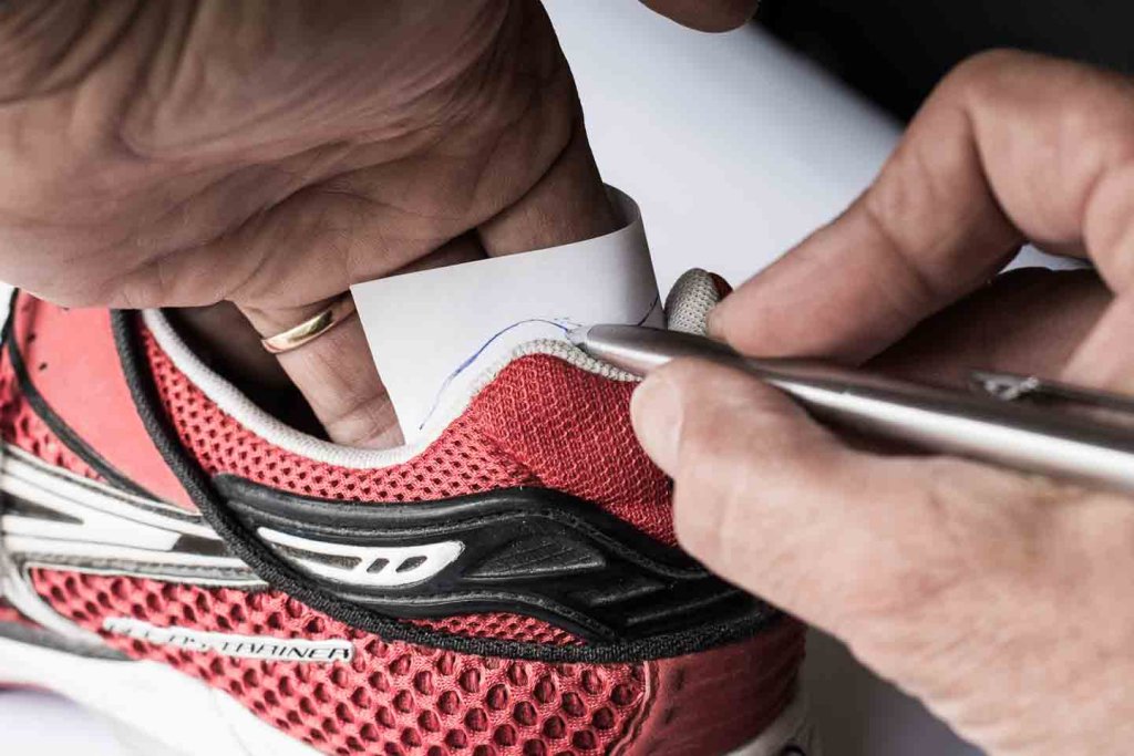 Fersenkappe reparieren – Schablone im Laufschuh anfertigen FersenkappengscDiagrammHast du dich schon einmal über durchgescheuerte Fersenkappen deiner Laufschuhe oder Sneakers geärgert? Wenn ein Loch entsteht, steigt die Wahrscheinlichkeit, dass du dir Blasen läufst. Ausserdem kann das Loch sich so weit ausdehnen, dass der gesamte Polsterbereich aufreisst und du die Schuhe entsorgen musst. Das muss nicht sein! Mit ein wenig Bastelarbeit kannst du das leicht beschädigte Gewebe der Fersenkappe reparieren, bevor ein großsss Loch entsteht. <h2>Durchgescheuerte Fersenkappen reparieren bei Sneakers und Laufschuhen</h2> <img class="alignright wp-image-9209 size-medium" title="Durchgescheuerte Fersenkappen reparieren - ON Cloudflash Laufschuhe" src="https://lauftipps.ch/wp-content/uploads/2022/04/Duchgescheuerte-Fersenkappen-reparieren-300x200.jpg" alt="Durchgescheuerte Fersenkappen reparieren - ON Cloudflash Laufschuhe" width="300" height="200" />Die mechanische Belastung beim Laufen ist besonders im Fersenbereich sehr hoch. Dort treten oft die ersten Schäden bei Laufschuhen auf, wie durchgescheuertes oder aufgerissenes Fersenfutter oder sogar grosse Löcher. Ist das Obermaterial einmal beschädigt, bleibt das weiche Polstermaterial darunter ungeschützt, und das Loch wird immer umfangreicher. Beschädigtes Obermaterial stört nicht nur beim Laufen, sondern erhöht auch das Risiko, dass an diesen Stellen durch den ungleichmässigen Druck <a href="https://lauftipps.ch/sportverletzungen/fussblasen-vermeiden/">Blasen an den Füssen</a> entstehen. Meine ersten Laufschuhe hatten noch Glattleder in der Fersenschale. Dieses Material war nahezu unzerstörbar, jedoch anfälliger für Blasen, insbesondere wenn die Socken feucht wurden. Überprüfe regelmässig das Material im Fersenbereich deiner Laufschuhe oder Sneakers. Wenn du erste Abnutzungserscheinungen bemerkst, solltest du die Kontrollen in kürzeren Abständen durchführen. Es ist einfacher, eine stark beanspruchte Stelle im Fersenfutter abzudecken, als ein großes Loch zu reparieren. <a title="Laufschuhe kaufen" href="https://lauftipps.ch/ausruestung/laufschuhe/laufschuhe-kaufen/">» Laufschuhe kaufen - Tipps für deinen optimalen Laufschuh</a> <h3>Anleitung: Durchgescheuerte Fersenkappen reparieren</h3> Mit einem einfachen Basteltipp zeige ich dir, wie du ein aufgerissenes Fersenfutter vermeiden und deine Laufschuhe oder Sneakers länger nutzen kannst. Dafür benötigst du: <ul> <li>ein kleines Blatt Papier</li> <li>einen Kugelschreiber</li> <li>eine Schere</li> <li>selbstklebendes Flickmaterial (Nylon, Stoff, Leder usw.) aus der Nähabteilung deines Warenhauses</li> </ul> <img class="alignright wp-image-9211 size-medium" title="Durchgescheuerte Fersenkappen reparieren - Asics DS Trainer Laufschuhe" src="https://lauftipps.ch/wp-content/uploads/2022/04/Durchgescheuerte-Fersenkappen-reparieren-2-300x200.jpg" alt="Durchgescheuerte Fersenkappen reparieren - Asics DS Trainer Laufschuhe" width="300" height="200" /> Zuerst nimmst du die Einlegesohle aus dem Schuh. Lege dann ein A6-Blatt (ein Viertel eines A4-Blattes) quer in den Fersenbereich des Schuhs und forme es so, dass es gut an die Fersenschale anliegt. Fahre mit einem Stift entlang der oberen Kante der Fersenschale, um die Form des Reparaturbereichs zu erfassen. Da beide Schuhe die gleiche Fersenschale haben, musst du dies nur an einem Schuh nachzeichnen. Entferne das Blatt aus dem Schuh und schneide am unteren Rand einen Zentimeter Papier waagerecht ab. So erhältst du oben automatisch einen kleinen Rand, damit das Flickmaterial nicht über die Fersenschale deines Schuhs hinausragt. <img class="alignright wp-image-9213 size-medium" title="Durchgescheuerte Fersenkappen reparieren 3 - Asics DS Trainer Laufschuhe" src="https://lauftipps.ch/wp-content/uploads/2022/04/Durchgescheuerte-Fersenkappen-reparieren-3-300x200.jpg" alt="Durchgescheuerte Fersenkappen reparieren 3 - Asics DS Trainer Laufschuhe" width="300" height="200" /> Schneide das Blatt an der markierten Linie (oberer Rand der Fersenschale) mit einer Schere oder einem Cutter aus. Übertrage die Vorlage einmal mit der Vorderseite und einmal mit der Rückseite auf die Rückseite des Flickmaterials, sodass der rechte und der linke Schuh symmetrisch gespiegelt sind. Oft ist es schwierig oder sogar unmöglich, die gesamte Klebefolie auf einmal im Fersenbereich anzubringen. Du kannst das Stück senkrecht dritteln und zuerst die linke, dann die rechte Seite und schließlich den mittleren Teil leicht überlappend als Streifen einkleben. So verhinderst du Falten oder Blasen beim Anbringen des dünnen Materials. Ich empfehle, den Bereich, den du später abkleben möchtest, mit einem Fön gut aufzuwärmen. Dadurch hält das Stück deutlich länger. Achte darauf, dass die oberen Ränder gut angedrückt sind. Es lohnt sich, den Flick für einige Sekunden mit Druck festzuhalten. <img class="alignright wp-image-9214 size-medium" title="Durchgescheuerte Fersenkappen reparieren 4" src="https://lauftipps.ch/wp-content/uploads/2022/04/Durchgescheuerte-Fersenkappen-reparieren-4-300x200.jpg" alt="Durchgescheuerte Fersenkappen reparieren 4" width="300" height="200" /> Während die Flicken recht gut halten, fransen zunächst die Ränder aus. Dann wird es bald Zeit, den Flick durch einen neuen zu ersetzen. Bewahre die „Schablone“ auf dem Papier auf und notiere, falls du mehrere Laufschuhe oder Sneakers besitzt, das genaue Modell auf der Schablone. Das Flickmaterial ist sehr strapazierfähig und schützt das Obermaterial vor weiterer Abnutzung. Wenn das Flickmaterial nach vielen Kilometern abgenutzt ist und an der oberen Kante ausfranst oder „Eselsohren“ bildet, entferne es und klebe ein frisches Stück auf. So kannst du deine Lieblingslaufschuhe oder Sneakers eine Weile länger tragen und gleichzeitig die Umwelt schonen. Wenn du es professionell machen lassen möchtest, hilft dir der Schuhmacher gerne weiter. <a title="Wie hoch ist die Lebensdauer von Laufschuhen?" href="https://lauftipps.ch/ausruestung/laufschuhe/lebensdauer-von-laufschuhen/">» Wie hoch ist die Lebensdauer von Laufschuhen?</a> <a title="Neue Laufschuhe einlaufen?" href="https://lauftipps.ch/ausruestung/laufschuhe/neue-laufschuhe-einlaufen/">» Muss ich Laufschuhe einlaufen?</a> <span style="font-size: 10pt;"><em><a title="Seitencode Funktion" href="https://lauftipps.ch/seitencode-funktion/">Seitencode</a>: LT926</em></span> Die nächste Seite, die ich SEO optimieren und einfach allgemein aktualisieren möchte. Wie gewohnt deine Einschätzung und dein HTML-Code als Vorschlag mit gelben Markierungen, wo ich zusätzlich etwas schreiben, ein neues Bild einfügen könnte. Ich prüfe zuerst kurz die GSC-Datei zum Artikel, damit die Überarbeitung nicht nur sprachlich, sondern auch nach Suchintention und vorhandenen Suchanfragen ausgerichtet ist. Danach gebe ich dir Einschätzung, Meta-Daten, Bild-/Link-Hinweise und den kompletten HTML-Vorschlag mit gelben Markierungen. Nachgedacht für 25s Einschätzung: Der Artikel hat gutes Potenzial. GSC zeigt Ø Position 6.67, aber nur 2.89 % CTR. Hauptchance: Titel/Snippet stärker auf „Schuhe/Fersenkappe reparieren“, Kosten vermeiden und Anleitung ausrichten. Wichtigster Fehler im Text: „großsss“ → „grosses“. Empfohlener H1: Fersenkappe reparieren: So rettest du Laufschuhe und Sneakers SEO-Titel: Fersenkappe reparieren: Anleitung für Laufschuhe & Sneakers Meta-Description: Durchgescheuerte Fersenkappe im Schuh? Mit dieser einfachen Anleitung reparierst du Laufschuhe und Sneakers, bevor Blasen oder grosse Löcher entstehen. Zusätzliches Bild sinnvoll: Ja: ein klares Vorher-nachher-Bild oder Nahaufnahme des eingeklebten Flicks. Dateiname: fersenkappe-reparieren-vorher-nachher-laufschuh.jpg Alt/Title: Fersenkappe reparieren – Vorher-nachher bei einem Laufschuh Seitencode: LT926 Die Links am Schluss habe ich reduziert und stärker in den passenden Kontext gesetzt. Besonders sinnvoll neu: Marathonschnürung, weil rutschende Fersen ein direkter Grund für durchgescheuerte Fersenkappen sein können. Überprüfe den Text stilistisch und bezüglich Rechtschreibung. Ja. Der Artikel ist bereits ordentlich geschrieben, aber ich würde vor einer Neuveröffentlichung einige sprachliche und stilistische Punkte korrigieren bzw. modernisieren. Rechtschreibung und Grammatik 1. Schreibfehler ❌ bevor ein großsss Loch entsteht ✅ bevor ein grosses Loch entsteht 2. Wortwiederholung ❌ durchgescheuertes oder aufgerissenes Fersenfutter oder sogar grosse Löcher Das "oder" kommt zweimal direkt hintereinander. ✅ Besser: durchgescheuertes oder aufgerissenes Fersenfutter sowie sogar grosse Löcher oder durchgescheuertes Fersenfutter, aufgerissene Innenmaterialien oder sogar grosse Löcher 3. Stilistisch etwas holprig ❌ Da beide Schuhe die gleiche Fersenschale haben, musst du dies nur an einem Schuh nachzeichnen. ✅ Da beide Schuhe in der Regel identisch aufgebaut sind, genügt es, die Vorlage an einem Schuh anzufertigen. 4. Ausdruck ❌ Das Flickmaterial ist sehr strapazierfähig Korrekt, aber etwas technisch. ✅ Das Flickmaterial ist überraschend strapazierfähig oder Das Flickmaterial hält selbst bei vielen Laufkilometern erstaunlich lange. Stilistische Verbesserungen Einstieg Der erste Absatz könnte emotionaler sein. Aktuell: Hast du dich schon einmal über durchgescheuerte Fersenkappen deiner Laufschuhe oder Sneakers geärgert? Stärker: Kaum sind die Laufschuhe richtig eingelaufen, zeigt sich bei vielen Modellen das gleiche Problem: Die Fersenkappe scheuert durch. Zuerst entsteht nur eine kleine Stelle im Innenfutter, später ein Loch, das beim Laufen stört und Blasen verursachen kann. Danach erst: Hast du dich schon einmal über durchgescheuerte Fersenkappen deiner Laufschuhe oder Sneakers geärgert? Schuhmacher-Abschnitt Der aktuelle Satz: Wenn du es professionell machen lassen möchtest, hilft dir der Schuhmacher gerne weiter. wirkt etwas abrupt. Besser: Wenn dir die Reparatur zu aufwendig ist oder der Schaden bereits grösser ausfällt, kann ein Schuhmacher die Fersenkappe oft professionell instand setzen. SEO-Potenzial Der Artikel rankt vermutlich auf: Fersenkappe reparieren Loch im Schuh innen Schuh innen kaputt Laufschuh Ferse kaputt Es fehlen aber einige Suchbegriffe vollständig. Ich würde natürlich im Text ergänzen: Ergänzung 1 Im Abschnitt "Wann lohnt sich eine Reparatur" Viele Läufer suchen nach Lösungen, wenn ein Loch im Schuh an der Ferse entsteht oder das Innenfutter des Schuhs beschädigt ist. In vielen Fällen lässt sich der Schaden mit wenig Aufwand stoppen. Ergänzung 2 Im Fazit Besonders bei hochwertigen Laufschuhen lohnt es sich oft, ein kleines Loch im Schuh frühzeitig zu reparieren, statt den Schuh sofort zu ersetzen. Interne Verlinkungen Die Verlinkung auf: Laufschuhe kaufen Lebensdauer von Laufschuhen Neue Laufschuhe einlaufen Marathonschnürung passt sehr gut. Zusätzlich würde ich noch einmal im Text verlinken: Fußblasen vermeiden → bereits vorhanden Wie viele Laufschuhe brauche ich? weil Nutzer, die ihre Schuhe möglichst lange nutzen möchten, oft mehrere Modelle im Wechsel tragen. Bilder Die bestehenden Bilder sind für eine Bastelanleitung völlig ausreichend. Für höhere CTR würde ich aber als Vorschaubild wählen: Variante 1 (beste CTR-Chance): Nahaufnahme eines deutlich durchgescheuerten Fersenbereichs Variante 2: Vorher-Nachher-Vergleich Ein Vorher-Nachher-Bild erzeugt erfahrungsgemäss deutlich mehr Klicks als ein Bild eines einzelnen Arbeitsschritts. Mein Gesamturteil Inhalt: 8.5/10 Lesbarkeit: 8/10 SEO aktuell: 7.5/10 Nach Überarbeitung: 9/10 Der Artikel gehört nicht zu den Seiten, die komplett neu aufgebaut werden müssen. Hier reichen gezielte Ergänzungen, ein stärkerer Einstieg, ein paar zusätzliche Suchbegriffe und ein besseres Vorschaubild. Das dürfte mehr bringen als weitere 500 Wörter Text. Durchgescheuerte Fersenkappe links an Sneaker, rechts an Laufschuh. Dateiname und tags? Das Bild eignet sich sehr gut für den Artikel. Es zeigt auf einen Blick sowohl eine reparierte Fersenkappe (links) als auch eine durchgescheuerte Fersenkappe mit Loch (rechts). Für die Suchintention „Fersenkappe reparieren“ ist das sogar stärker als die bisherigen Arbeitsschritt-Bilder. Dateiname fersenkappe-reparieren-laufschuh-sneaker-vorher-nachher.jpg Alternativen: durchgescheuerte-fersenkappe-reparieren.jpg oder fersenkappe-laufschuh-reparatur-vorher-nachher.jpg Alt-Tag Reparierte Fersenkappe an einem Sneaker links und durchgescheuerte Fersenkappe mit Loch an einem Laufschuh rechts Etwas kürzer: Vorher-Nachher-Vergleich einer reparierten und einer durchgescheuerten Fersenkappe Title-Tag Fersenkappe reparieren – Vergleich zwischen reparierter und beschädigter Fersenkappe oder Durchgescheuerte Fersenkappe bei Laufschuh und Sneaker Bildbeschreibung (falls WordPress-Feld verwendet wird) Links eine mit Flickmaterial reparierte Fersenkappe eines Sneakers, rechts eine durchgescheuerte Fersenkappe mit Loch an einem Laufschuh. Eine frühzeitige Reparatur kann die Lebensdauer von Schuhen deutlich verlängern. Meine Empfehlung als Vorschaubild Für die Artikelvorschau würde ich dieses Bild sogar den bisherigen Bildern vorziehen, weil: Problem und Lösung gleichzeitig sichtbar hoher Wiedererkennungswert funktioniert auch in kleiner Darstellung unterstützt die Suchanfrage „Fersenkappe reparieren“ unmittelbar erzeugt mehr Neugier als ein einzelner Arbeitsschritt Das ist wahrscheinlich das stärkste Bild, das du aktuell für diesen Artikel hast. Es ist kein Vergleich repariert oder nicht. Zwei verschiedene Schuhmodelle mit Schäden Guter Hinweis. Dann sollte der Alt-Text das Bild möglichst sachlich beschreiben und nichts suggerieren, was nicht sichtbar ist. Ich würde es so formulieren: Dateiname durchgescheuerte-fersenkappen-laufschuh-sneaker.jpg oder beschaedigte-fersenkappen-sneaker-laufschuh.jpg Alt-Tag Durchgescheuerte Fersenkappe an einem Sneaker links und an einem Laufschuh rechts oder etwas ausführlicher: Beschädigte Fersenkappen mit Abnutzungsspuren an einem Sneaker und einem Laufschuh Title-Tag Durchgescheuerte Fersenkappen bei Sneaker und Laufschuh Bildbeschreibung Durchgescheuerte Fersenkappen bei zwei verschiedenen Schuhmodellen. Links ein Sneaker mit Abnutzung des Innenfutters, rechts ein Laufschuh mit einem Loch im Fersenbereich. Für SEO gefällt mir die Kombination am besten: Dateiname: durchgescheuerte-fersenkappen-laufschuh-sneaker.jpg Alt: Durchgescheuerte Fersenkappe an einem Sneaker links und an einem Laufschuh rechts Title: Durchgescheuerte Fersenkappen bei Sneaker und Laufschuh Damit deckst du die Suchbegriffe Fersenkappe, durchgescheuert, Laufschuh und Sneaker natürlich ab, ohne etwas zu behaupten, das auf dem Bild nicht erkennbar ist. Positionen für den Flick, in zwei Teilen unter "Flickmaterial passend zuschneiden" Ja, dieses Bild passt hervorragend genau an die Stelle „Flickmaterial passend zuschneiden“. Es zeigt sehr anschaulich: die Papierschablone im Schuh die Position des Flickmaterials im Fersenbereich dass das Material nicht bis ganz nach oben reichen muss wie die Form der Fersenkappe übernommen wird Eigentlich erklärt dieses Bild den Arbeitsschritt sogar besser als die bisherigen Fotos. Dateiname flickmaterial-fersenkappe-zuschneiden-schablone.jpg oder fersenkappe-reparieren-schablone-flickmaterial.jpg Alt-Tag Papierschablone zur Anpassung des Flickmaterials für die Reparatur einer durchgescheuerten Fersenkappe Title-Tag Schablone für Flickmaterial bei der Reparatur einer Fersenkappe Bildbeschreibung Mit einer einfachen Papierschablone lässt sich die Form des Flickmaterials für die Reparatur einer durchgescheuerten Fersenkappe exakt an die Innenseite des Schuhs anpassen. Bildunterschrift (falls verwendet) <figcaption> Mit einer Papierschablone lässt sich das Flickmaterial exakt an die Form der Fersenkappe anpassen. </figcaption> Position im Artikel Direkt nach diesem Absatz: Schneide das Blatt an der markierten Linie mit einer Schere oder einem Cutter aus. Übertrage die Vorlage einmal mit der Vorderseite und einmal mit der Rückseite auf die Rückseite des Flickmaterials, sodass der rechte und der linke Schuh symmetrisch gespiegelt sind. Und vor diesem Absatz: Oft ist es schwierig oder sogar unmöglich, die gesamte Klebefolie auf einmal im Fersenbereich anzubringen. Dadurch sieht der Leser zuerst die Schablone und versteht danach sofort, warum das Material eventuell in mehrere Streifen geteilt wird. Das verbessert den Lesefluss deutlich. Bild für "Einlegesohlen herausnehmen und Schablone anfertigen) Ja, dieses Bild ist sogar noch passender für diesen Arbeitsschritt als das vorherige. Es zeigt exakt das, was im Text beschrieben wird: Papier wird in die Fersenschale gelegt Form der Fersenkappe wird abgezeichnet Vorlage für das Flickmaterial entsteht Leser erkennt sofort, wie die Schablone hergestellt wird Dateiname fersenkappe-schablone-anfertigen.jpg oder etwas SEO-stärker: schablone-fersenkappe-reparieren-laufschuh.jpg Alt-Tag Schablone für die Reparatur einer durchgescheuerten Fersenkappe in einem Laufschuh anfertigen Title-Tag Fersenkappe reparieren – Schablone im Laufschuh anfertigen Bildbeschreibung Mit einem Blatt Papier wird die Form der Fersenkappe direkt im Schuh nachgezeichnet. Die Schablone dient später als Vorlage für das Zuschneiden des Flickmaterials. Bildunterschrift <figcaption> Die Form der Fersenkappe wird mit einer einfachen Papierschablone direkt im Schuh nachgezeichnet. </figcaption> Position im Artikel Direkt nach diesem Absatz: Zuerst nimmst du die Einlegesohle aus dem Schuh. Lege dann ein A6-Blatt (ein Viertel eines A4-Blattes) quer in den Fersenbereich des Schuhs und forme es so, dass es gut an die Fersenschale anliegt. Fahre mit einem Stift entlang der oberen Kante der Fersenschale, um die Form des Reparaturbereichs zu erfassen. Das Bild illustriert genau diesen Satz und verbessert die Verständlichkeit der Anleitung deutlich. Meine Reihenfolge der Bilder wäre dann: Titelbild: Durchgescheuerte Fersenkappen bei Sneaker und Laufschuh Schablone anfertigen (dieses Bild) Papierschablone im Schuh positionieren (dein vorheriges Bild) Flickmaterial zuschneiden Fertige Reparatur Dadurch entsteht ein logisch aufgebauter Ablauf, der den Leser Schritt für Schritt durch die Reparatur führt. Sneaker mit eingeklebtem dünnen Stoff. Dieses Bild gefällt mir für den Artikel besonders gut, weil es eine fertige Reparatur in der Praxis zeigt. Der Leser erkennt sofort, wie das Ergebnis aussehen soll. Ich würde es im Abschnitt „Wie lange hält die Reparatur?“ oder direkt vor dem Fazit platzieren. Dateiname fersenkappe-repariert-sneaker.jpg oder reparierte-fersenkappe-mit-flickmaterial.jpg Alt-Tag Sneaker mit eingeklebtem Flickmaterial zur Reparatur einer durchgescheuerten Fersenkappe Title-Tag Fersenkappe reparieren – eingeklebtes Flickmaterial in einem Sneaker Bildbeschreibung Ein dünnes Stück selbstklebendes Flickmaterial schützt die beschädigte Fersenkappe eines Sneakers vor weiterer Abnutzung und verlängert die Lebensdauer des Schuhs. Bildunterschrift <figcaption> Das dünne Flickmaterial schützt die Fersenkappe vor weiterer Abnutzung und ist beim Tragen kaum spürbar. </figcaption> SEO-Hinweis Das Bild ist wertvoller als viele der alten Fotos, weil es genau das Suchziel zeigt: Problem gelöst Reparatur fertig Ergebnis sichtbar Ich würde deshalb heute die Bilder ungefähr so gewichten: Titelbild: Durchgescheuerte Fersenkappen (Sneaker + Laufschuh) Schablone anfertigen Schablone im Schuh positionieren Fertig eingeklebtes Flickmaterial ← dieses Bild Die älteren Bilder mit dem Asics-Schuh nur noch ergänzend oder teilweise ersetzen. Dadurch wirkt der Artikel moderner und zeigt mehr eigene Erfahrungen statt allgemeiner Bastelschritte. Das passt sehr gut zum Stil von Lauftipps.ch. Mit der ZEit fransen die Flicke uas Genau. Dieses Bild passt hervorragend zu diesem Absatz: Während die Flicken recht gut halten, fransen zunächst die Ränder aus. Dann wird es bald Zeit, den Flick durch einen neuen zu ersetzen. Das Foto zeigt genau das Problem: Der Flick hält noch, aber die Kanten beginnen sich aufzulösen. Dateiname flickmaterial-fersenkappe-ausgefranst.jpg oder fersenkappe-flick-ausfransende-raender.jpg Alt-Tag Ausgefranste Ränder eines Flickmaterials zur Reparatur einer Fersenkappe Title-Tag Fersenkappe reparieren – ausgefranste Kanten des Flickmaterials Bildbeschreibung Nach vielen Laufkilometern können die Ränder des Flickmaterials ausfransen. In diesem Fall lässt sich der alte Flick einfach entfernen und durch einen neuen ersetzen. Bildunterschrift <figcaption> Nach längerer Nutzung fransen die Ränder des Flickmaterials aus. Dann wird es Zeit für einen neuen Flick. </figcaption> SEO-Vorteil Dieses Bild ist aus SEO-Sicht überraschend wertvoll, weil es eine Frage beantwortet, die viele Leser haben: „Wie lange hält so eine Reparatur überhaupt?“ Du zeigst damit: Die Reparatur funktioniert. Sie hält lange. Irgendwann nutzt sich nur der Flick ab. Der Schuh selbst bleibt geschützt. Das erhöht die Glaubwürdigkeit der ganzen Anleitung deutlich stärker als ein weiteres Foto vom Zuschneiden oder Einkleben. Meine Favoriten für den Artikel wären mittlerweile: Titelbild: durchgescheuerte Fersenkappen (zwei Schuhe) Schablone anfertigen Schablone/Flickmaterial positionieren Fertig eingeklebter Flick Ausgefranster Flick nach langer Nutzung Damit erzählst du praktisch die komplette Geschichte von Problem → Reparatur → Ergebnis → Langzeiterfahrung. Das ist genau die Art von eigenem Erfahrungsinhalt, die auf Lauftipps.ch besonders gut funktioniert. Welche Links wären passend für den Artikel unter "Das könnte dich ebenfalls interssieren" oder würdest du das weglassen? Bei diesem Artikel würde ich "Das könnte dich ebenfalls interessieren" nicht weglassen, aber deutlich kürzer halten als bei einem Trainingsartikel. Die Suchintention ist sehr konkret: Jemand hat ein Problem mit seinem Schuh und sucht eine Lösung. Zu viele Links lenken hier eher ab. Ich würde maximal 3–5 Links setzen. Sehr passend 1. Lebensdauer von Laufschuhen Passt perfekt, weil die Reparatur direkt mit der Verlängerung der Nutzungsdauer zusammenhängt. <li><a href="https://lauftipps.ch/ausruestung/laufschuhe/lebensdauer-von-laufschuhen/" title="Wie lange halten Laufschuhe?">Wie lange halten Laufschuhe?</a></li> 2. Laufschuhe kaufen Für Leser, die merken, dass eine Reparatur nicht mehr sinnvoll ist. <li><a href="https://lauftipps.ch/ausruestung/laufschuhe/laufschuhe-kaufen/" title="Tipps für den Kauf von Laufschuhen">Laufschuhe kaufen – Tipps für deinen optimalen Laufschuh</a></li> 3. Fussblasen vermeiden Direkter Bezug zur beschädigten Fersenkappe. <li><a href="https://lauftipps.ch/sportverletzungen/fussblasen-vermeiden/" title="Blasen an den Füssen vermeiden">Blasen an den Füssen vermeiden</a></li> Optional 4. Marathonschnürung Wenn du den neuen Abschnitt zur rutschenden Ferse einbaust. <li><a href="https://lauftipps.ch/ausruestung/laufschuhe/marathonschnuerung/" title="Marathonschnürung gegen rutschende Fersen">Marathonschnürung – wenn die Ferse im Schuh rutscht</a></li> Eher nicht Diese würde ich nicht aufnehmen: Neue Laufschuhe einlaufen Wie viele Laufschuhe brauche ich? Sprengung bei Laufschuhen Natural Running Wettkampfschuhe Der thematische Zusammenhang ist zu schwach. Meine Empfehlung Wenn du bereits im Artikel auf Laufschuhe kaufen, Lebensdauer von Laufschuhen und Blasen vermeiden verlinkst, würde ich am Schluss gar keinen weiteren Empfehlungsblock mehr einbauen. Das entspricht übrigens genau deiner bisherigen Strategie auf Lauftipps.ch: Bei grossen Ratgebern → 5–8 Empfehlungen am Schluss. Bei Problemlösungs-Artikeln wie diesem → Links direkt im Text statt zusätzlicher Linkblock. Für diesen Artikel würde ich deshalb wahrscheinlich auf "Das könnte dich ebenfalls interessieren" verzichten und die internen Links dort platzieren, wo sie thematisch passen. Das wirkt natürlicher und vermeidet unnötige Wiederholungen. Eingefügter Text(67).txt Dokument Kannst du überprüfen, ob alle Links einen title-Tag haben, die Bilder passende tags und, falls nötig, mir aufzeigen. Nachgedacht für 43s Ja. Alle 6 Links haben einen title-Tag. Auch die 6 Bilder haben jeweils alt- und title-Attribute. Kleine Optimierungen würde ich trotzdem machen: Bild 2: Alt aktuell: „Durchgescheuerte Fersenkappe bei einem Laufschuh reparieren“ Besser: Durchgescheuerte Fersenkappe bei einem Laufschuh vor der Reparatur Bild 4: Title aktuell: „Schablone für Flickmaterial bei der Reparatur einer Fersenkappe“ Besser: Flickmaterial für die Reparatur der Fersenkappe zuschneiden
